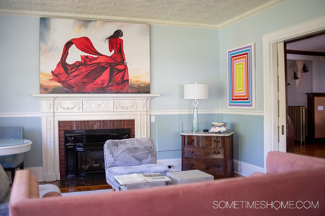 Seating area in a living room with couches and colorful paintings at a modern bed and breakfast in Bar Harbor, Maine.