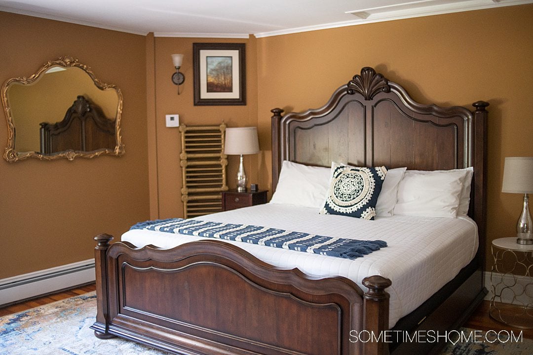 King size bed with a wooden headboard in a modern room at a bed and breakfast in Bar Harbor, Maine.