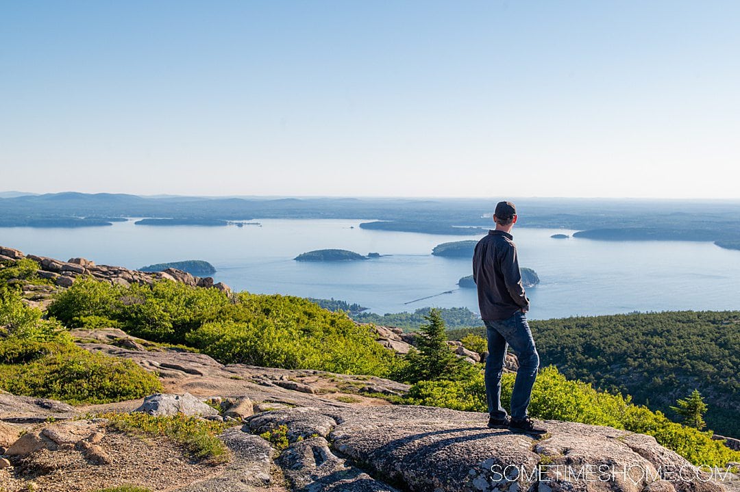 Man overlooking the view of Bar Harbor, Maine from Cadillac Summit in Acadia National Park.