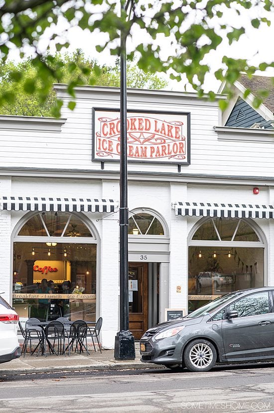 White facade with a red sign at Crooked Lake Ice Cream Parlor in Hammondsport, NY.