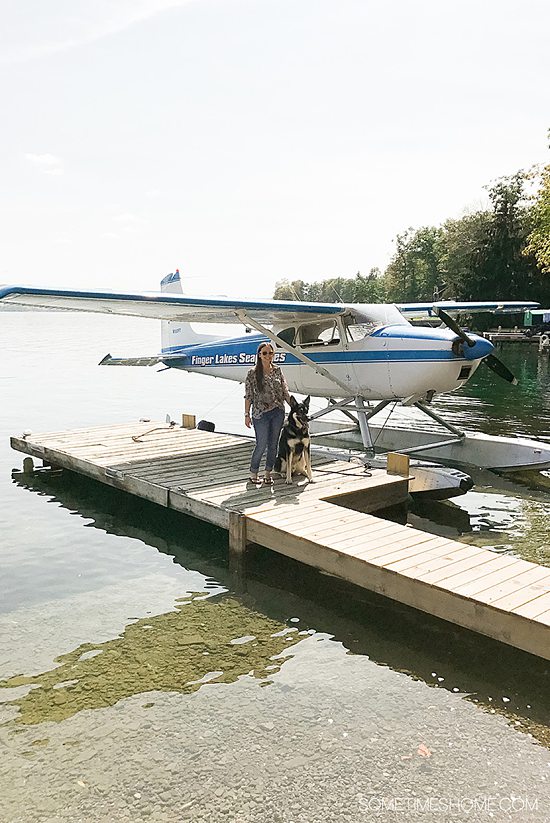 Woman and dog next to a seaplane on Keuka Lake, one of the best things to do in Hammondsport, NY.