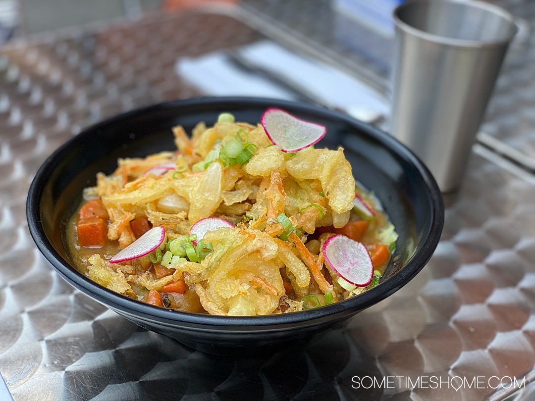 Udon curry soup in a black bowl, with tempura fried vegetables on top from M Kokko in Durham, NC.