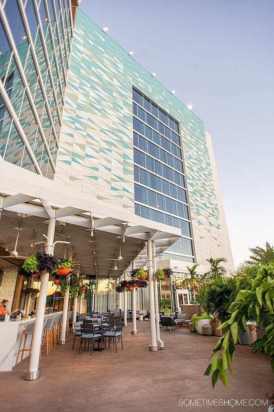 Hotel tower in the distance during sunset with a covered bar and dining area outside at the Swan Reserve.