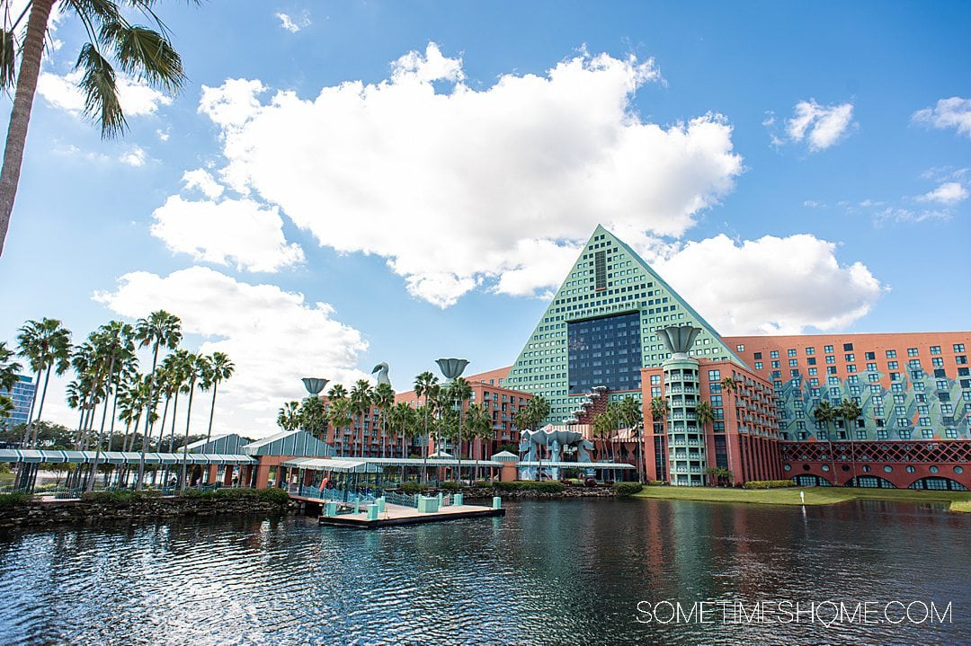 Boat area on a lake at the Dolphin hotel and resort at Walt Disney World, with blue skies and white clouds, and palm trees.