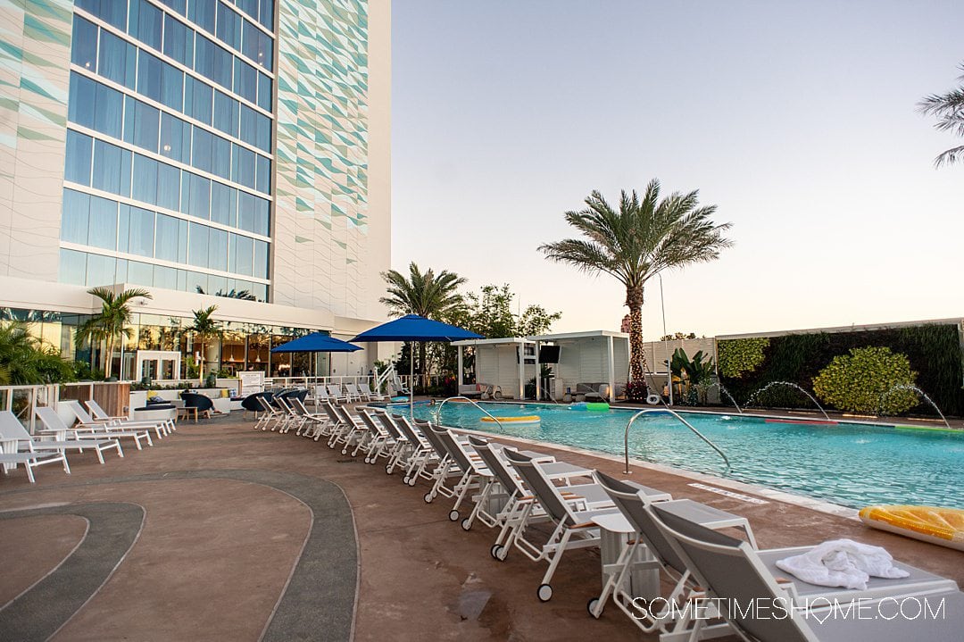 Pool with palm trees in the background and sunset lighting at the Swan Reserve resort at Disney World.