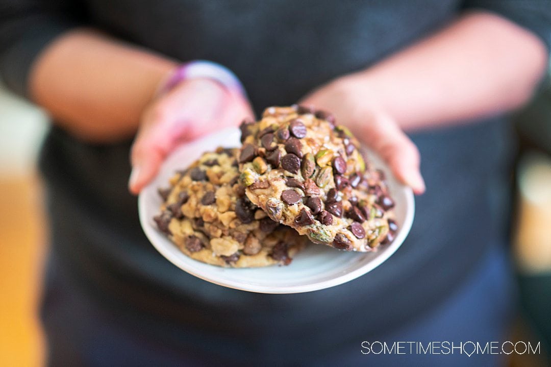 Hands holding a small plate with cookies on it from Gideon's at Disney Springs.