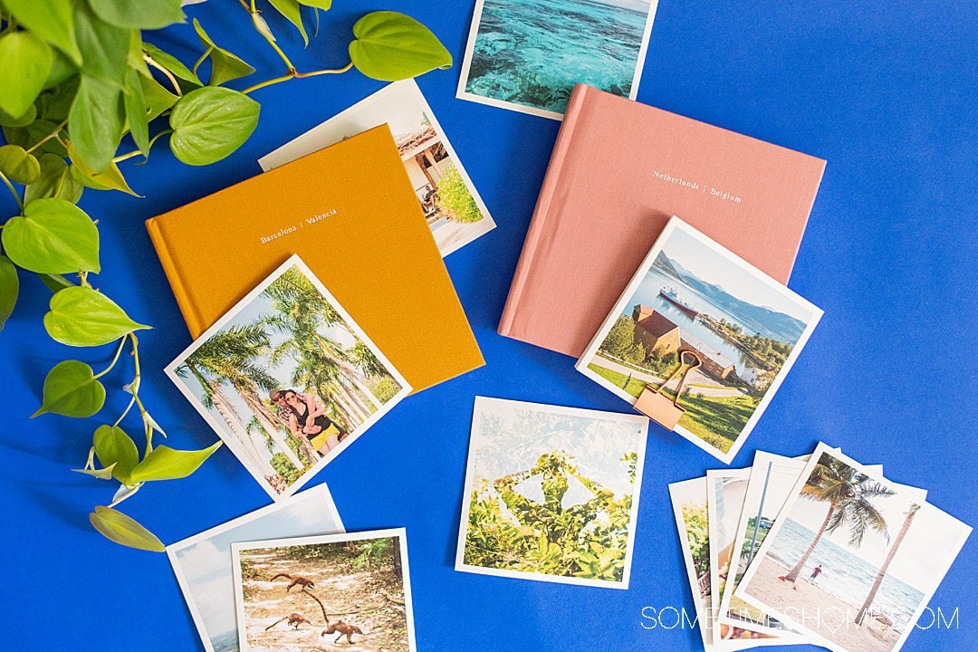 Two photo books open to picture pages on a blue background for an Artifact Uprising review.