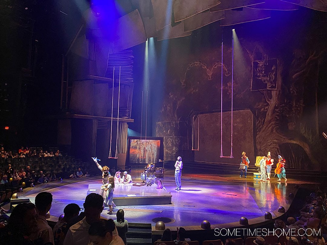 Pre-show of Cirque du Soleil Drawn to Life at Disney World, with colorful purple lighting and stage performers.