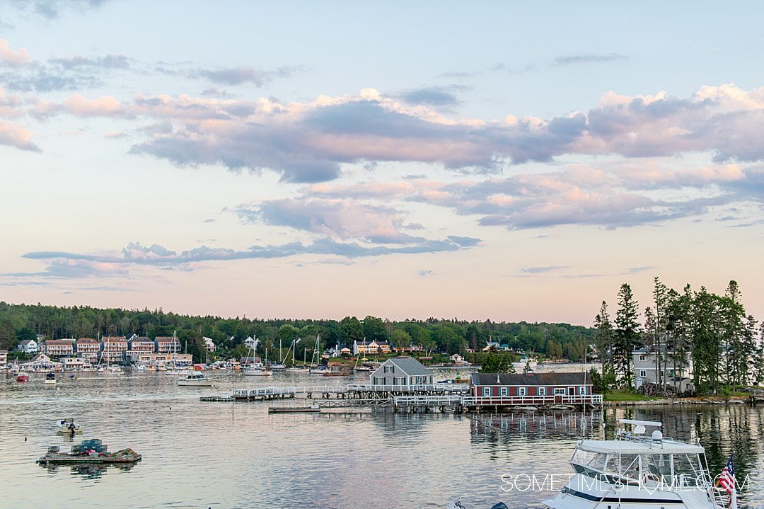 Maine coast sunset with purple and pink clouds, in Boothbay Harbor, part of a Maine coast road trip.