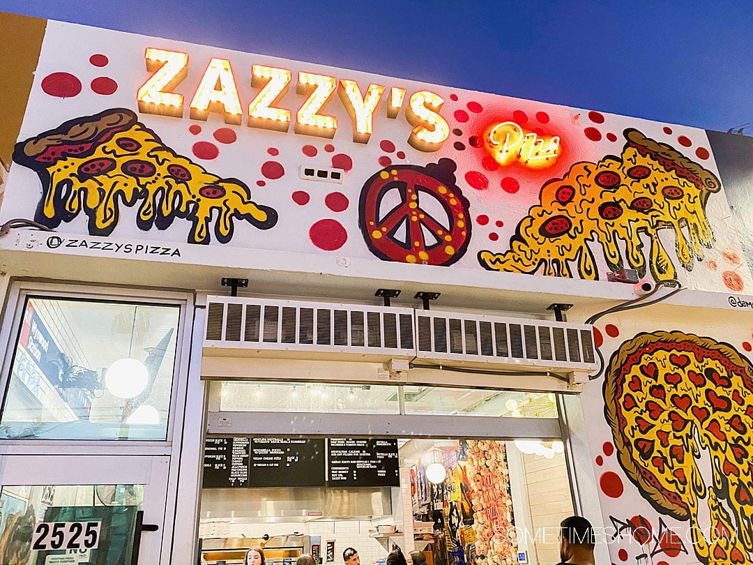 Zazzy's pizza sign in lights and pizza graphics with a peace sign in Wynwood, Florida.