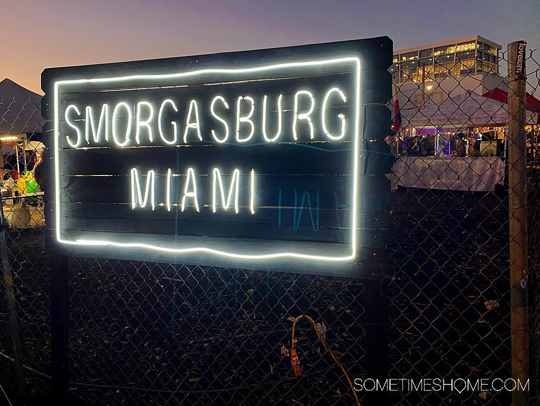 Neon sign of "Smorgasburg Miami" in Wynwood, at twilight.