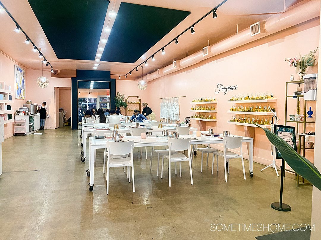 Inside a candle workshop in Wynwood, FL with white furniture and pink walls.