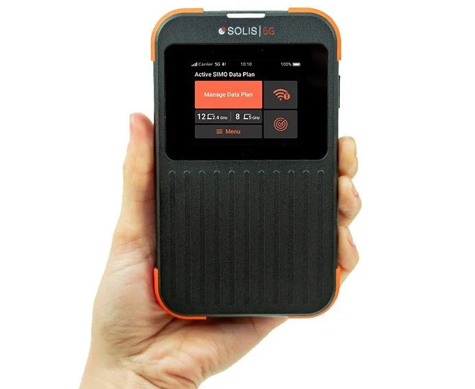 Hand holding a black rectangular wifi hotspot Solis 5G device.