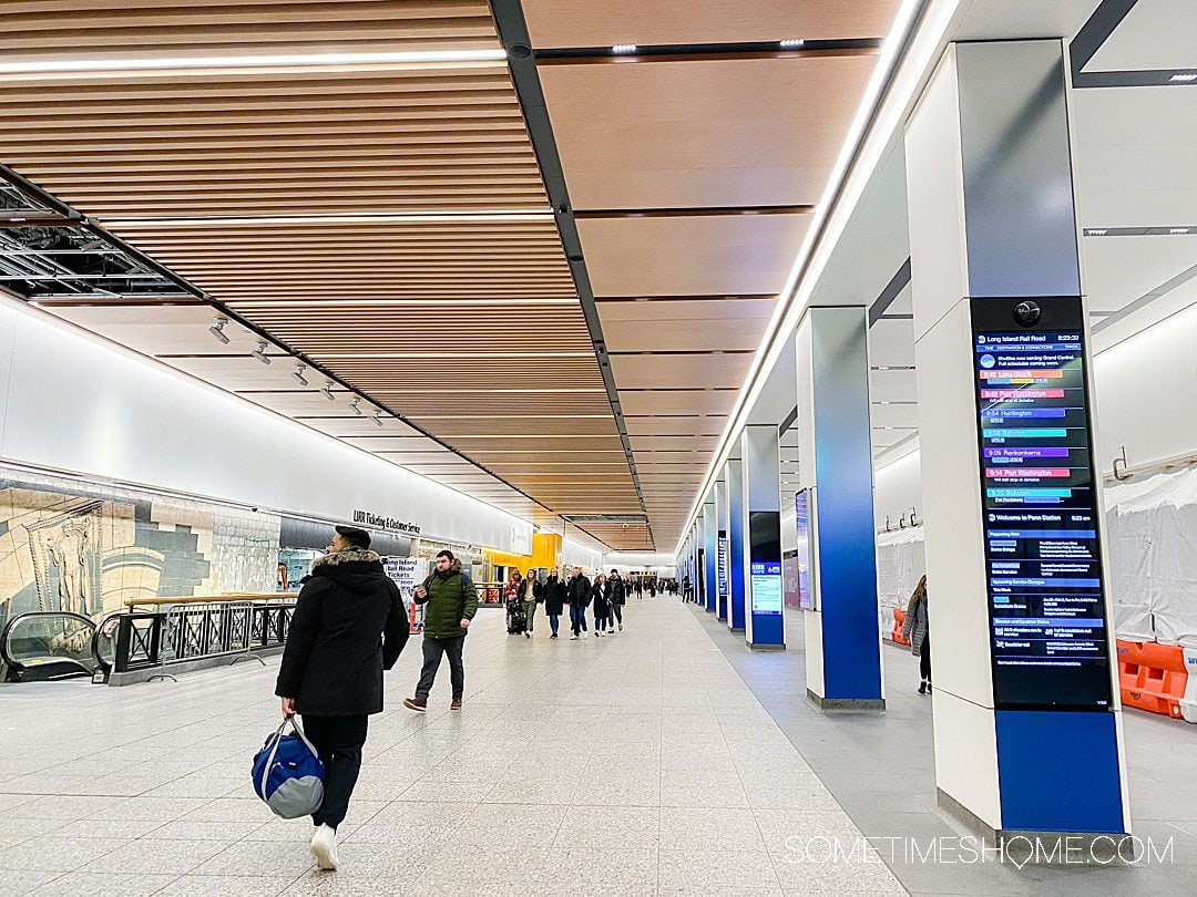 People walking at Penn Station to trains for LIRR.