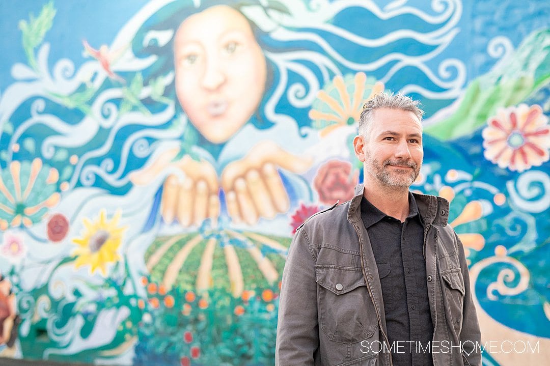Man in front of a colorful mural in downtown Santa Ana, California.