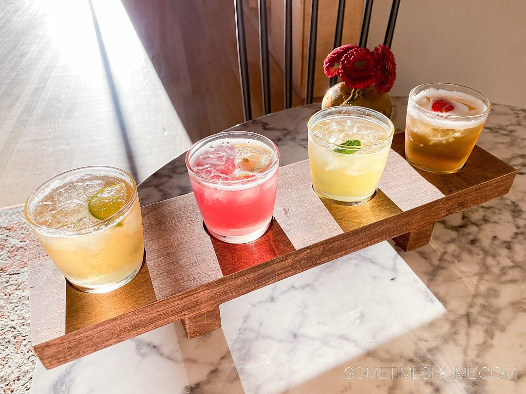 Wood board with a flight of iced teas at Chad's Chai in Winston-Salem, on a white marble table.