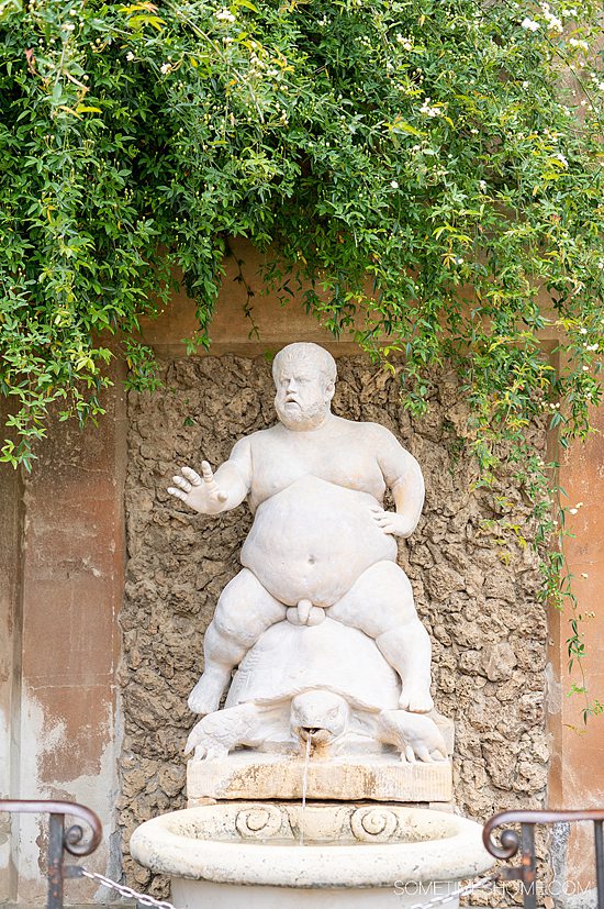 Statue of an overweight man sitting on a turtle fountain in Boboli Gardens in Italy.