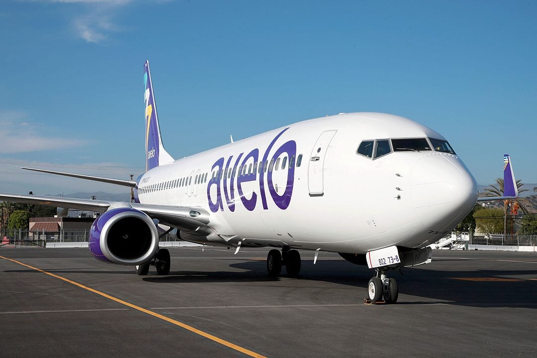 Avelo Airlines airplane with purple writing on the side.