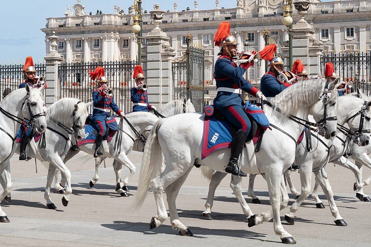 Royal Guard on white horseback in front of the Royal Palace of Madrid during an official ceremony.