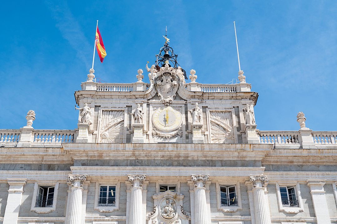 Top of the Royal Palace of Madrid with the Spanish flag raised on the left.