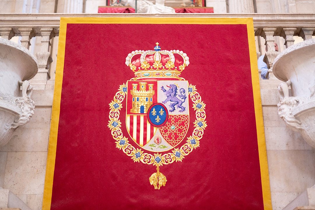 Red flag with the Royal Coat of Arms at the palace of Madrid.