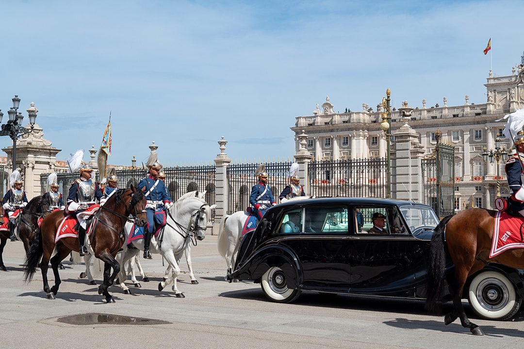 Black Rolls Royce and Royal Guard on horseback in front of the Royal Palace of Madrid.