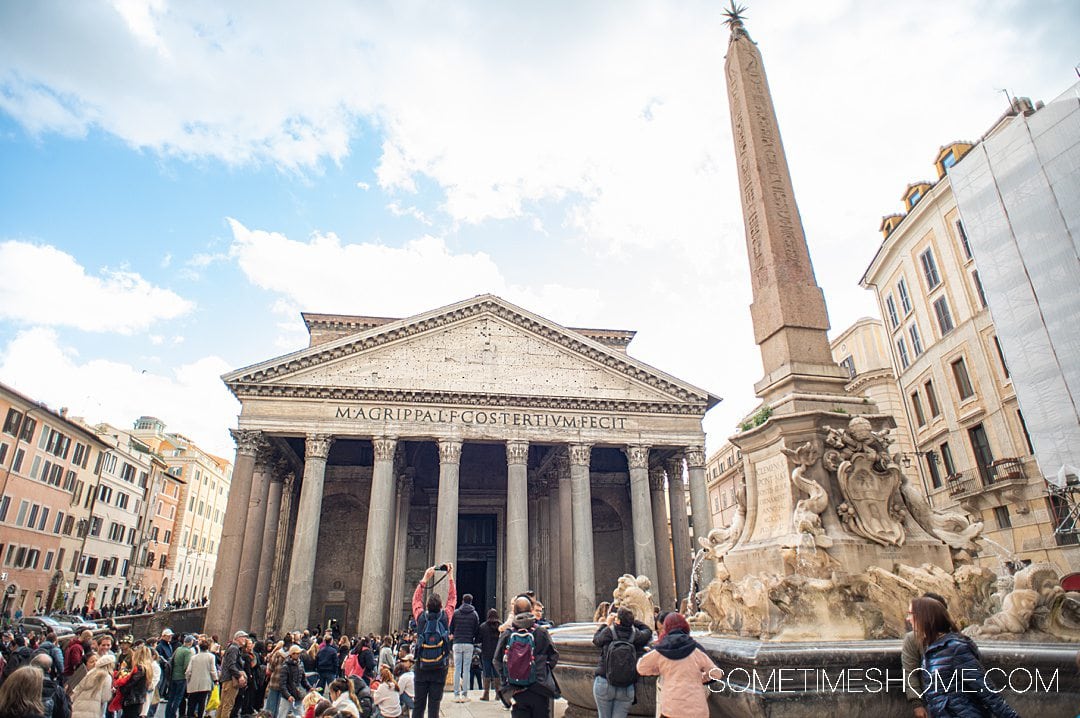 Outside of the Pantheon building in Rome with an obelisk on the right.