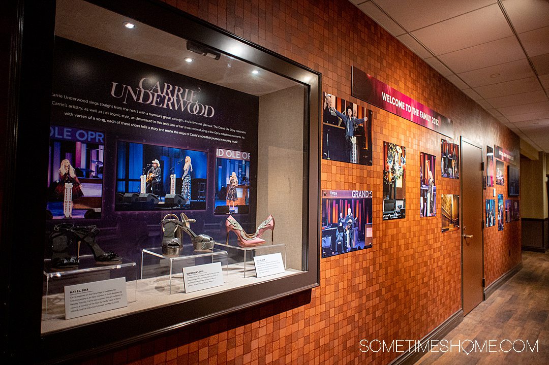 Glass exhibit case next to a wall with new inductees to the Grand Ole Opry.