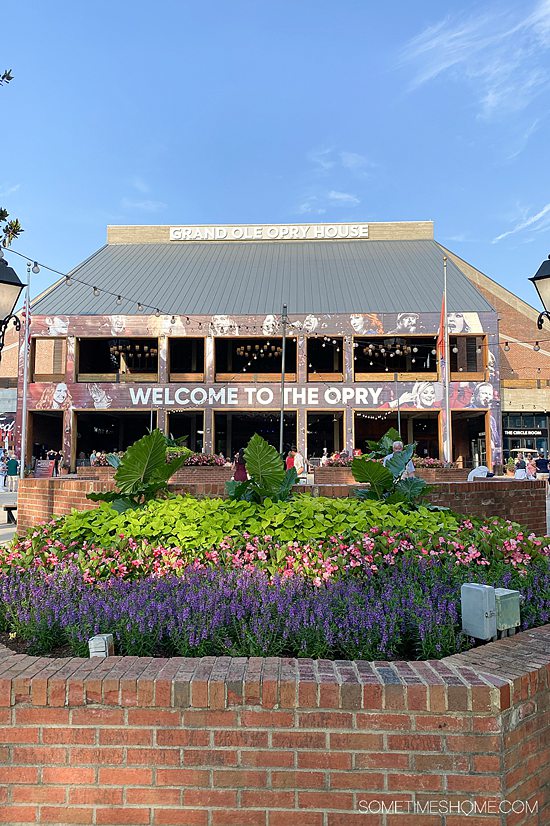 Front of the Grand Ole Opry building with a bed of colorful flowers in front of it.