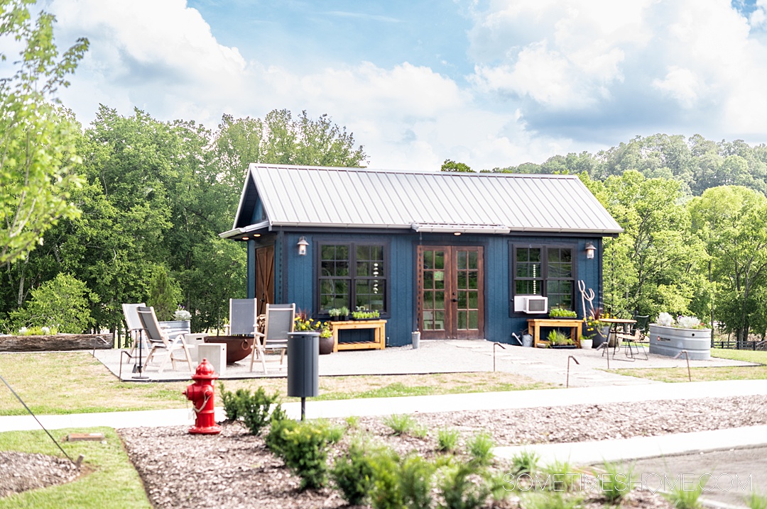 Small blue house in Leiper's Fork surrounded by green landscaping.