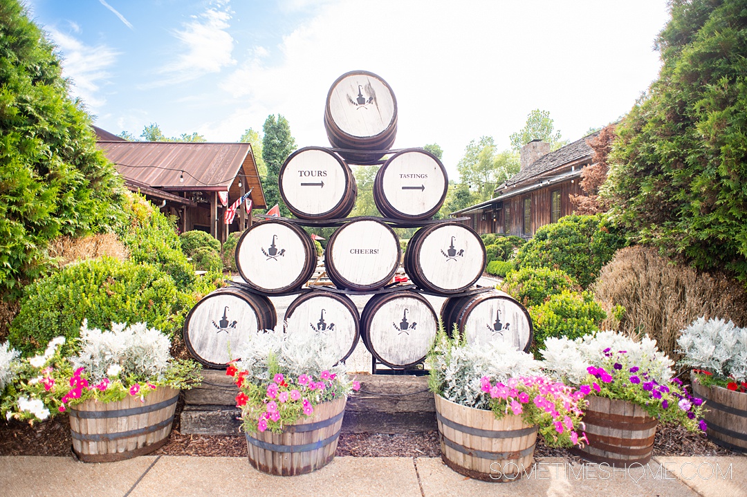 Barrels stacked in a pyramid with flowers in front of them at Leiper's Fork Distillery.
