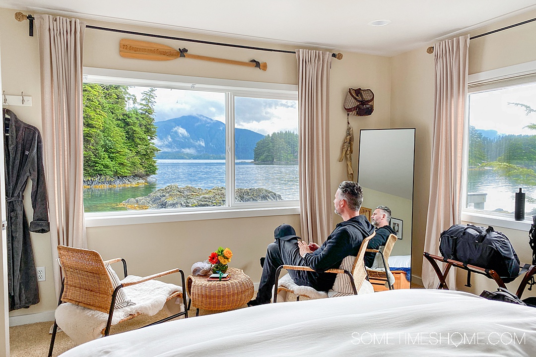 Man sitting on a chair in an all-inclusive resort in Alaska with a gorgeous waterfront view.