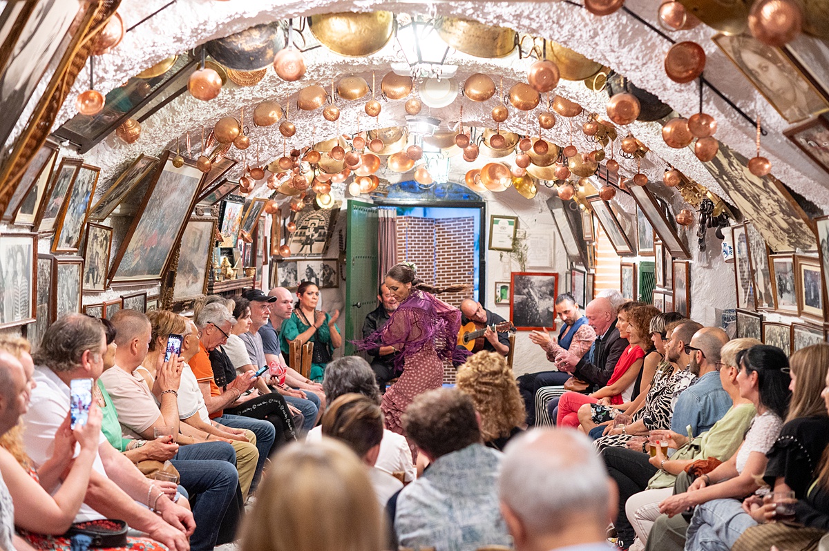 Flamenco dancer performing in a cave lined with copper pots on the ceiling in Granada