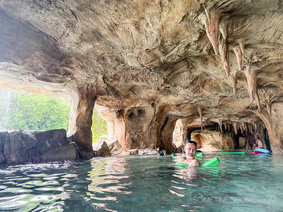 Man in a pool noodle in the distance in a cavernous area of the lazy river at Discovery Cove in Orlando, FL.