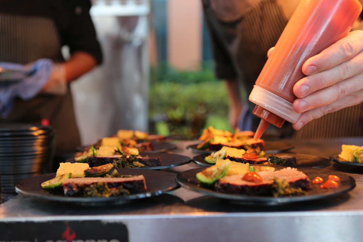A squeeze bottle puts a dab of condiment on a dish at the Food and Wine Classic in Central Florida.
