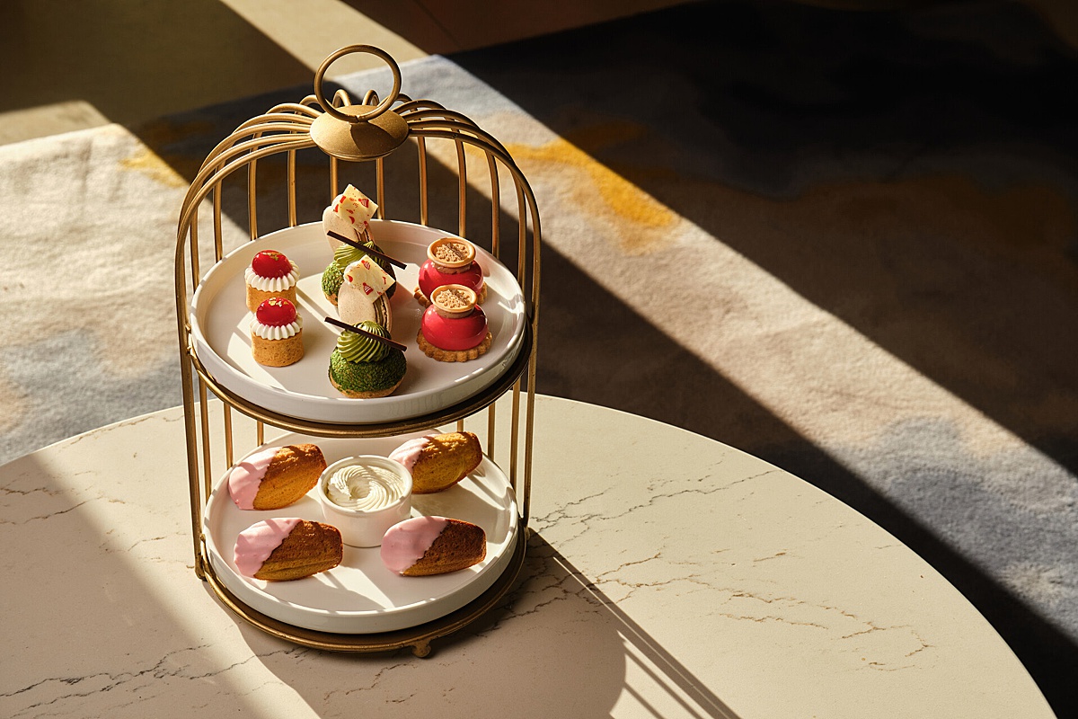 A table with a two-tiered afternoon tea tray with holidays treats, savory and sweet.
