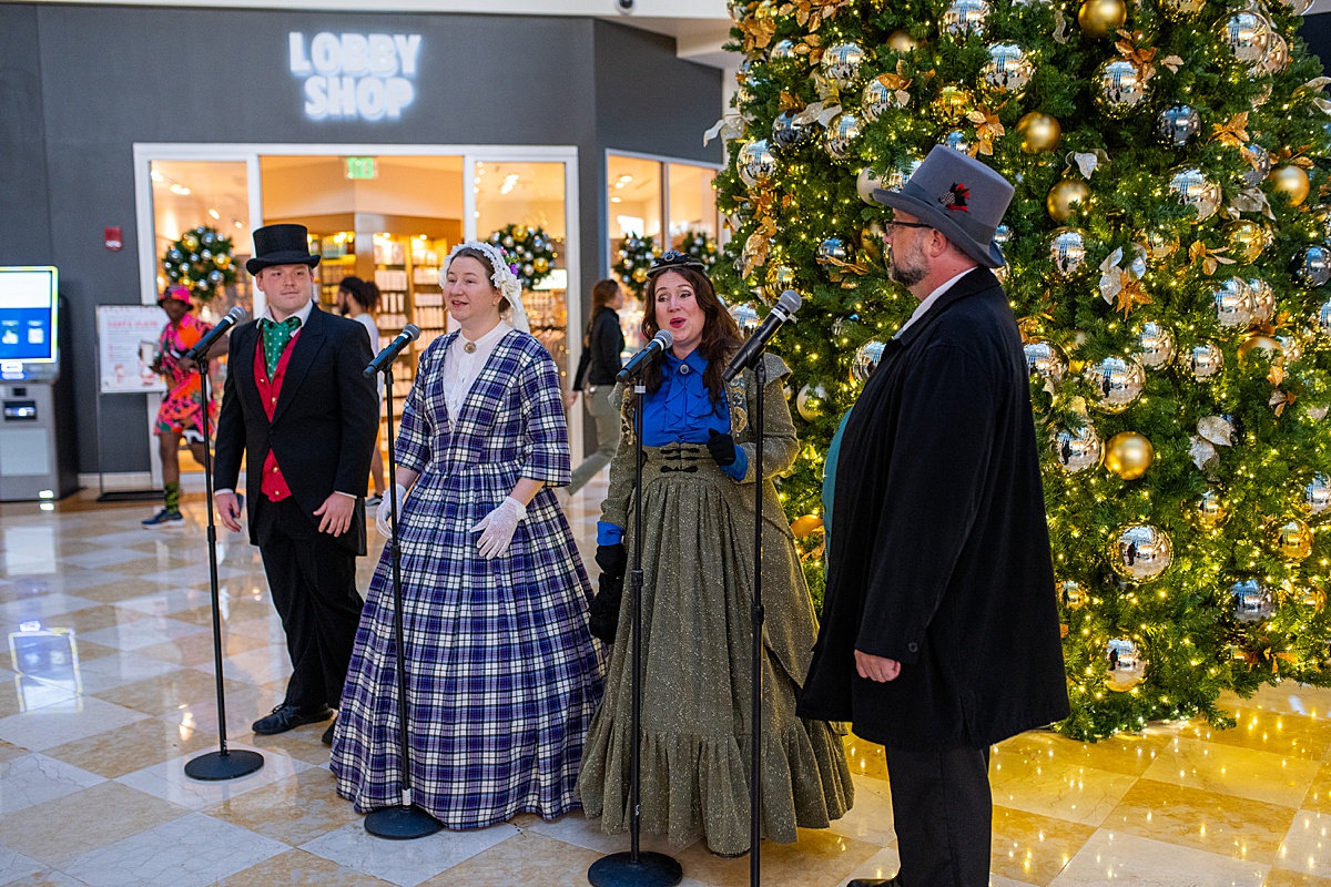 Christmas Carolers at the World Center Orlando Marriott with a holiday tree behind them.