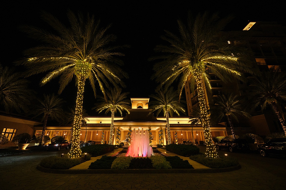 Night time at the Four Seasons Resort Orlando with palm trees in white twinkle lights in front of the hotel.