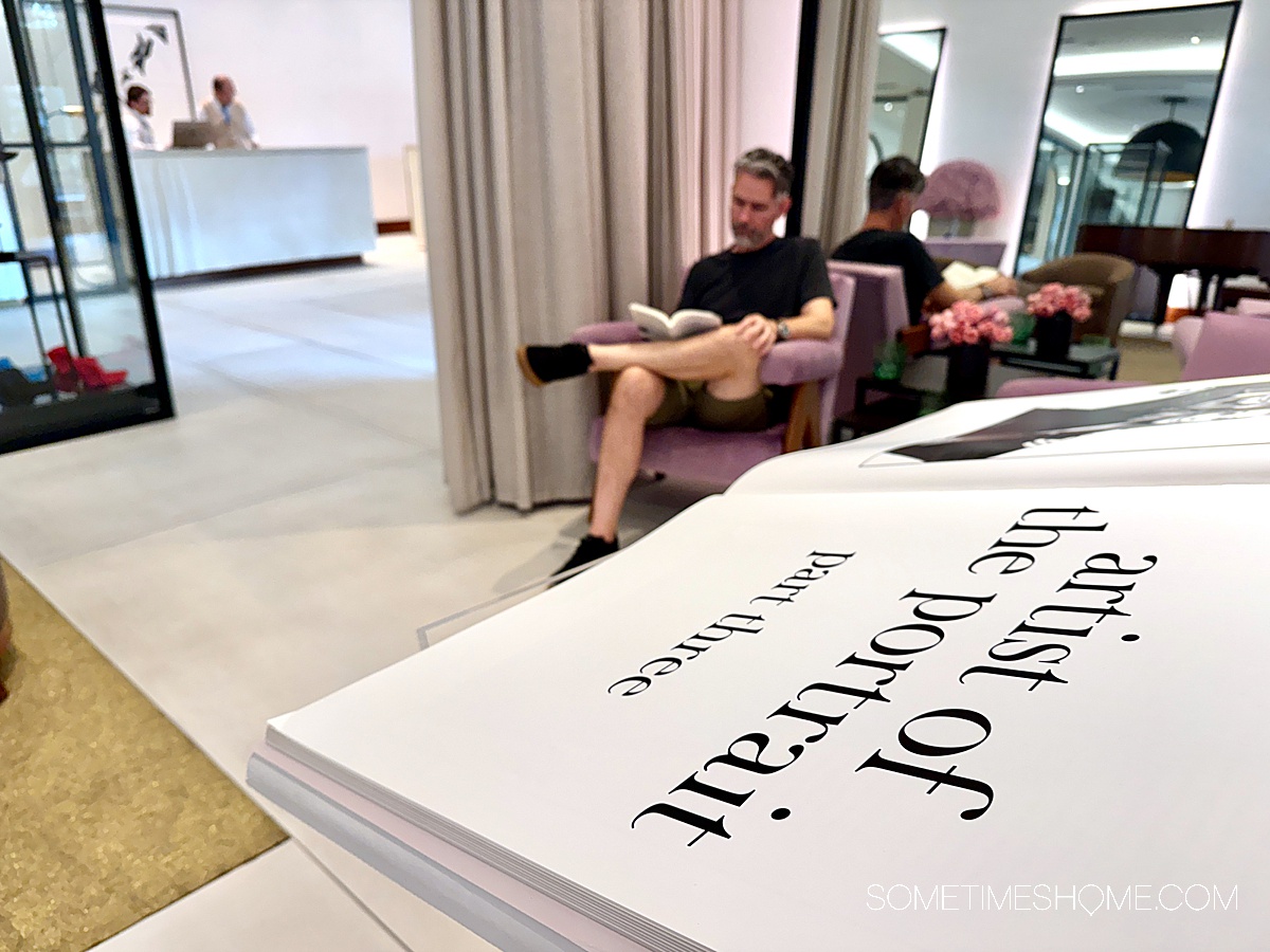Book in the foreground and in a man reading in the background at a hotel lobby, at the ette property in Kissimmee.
