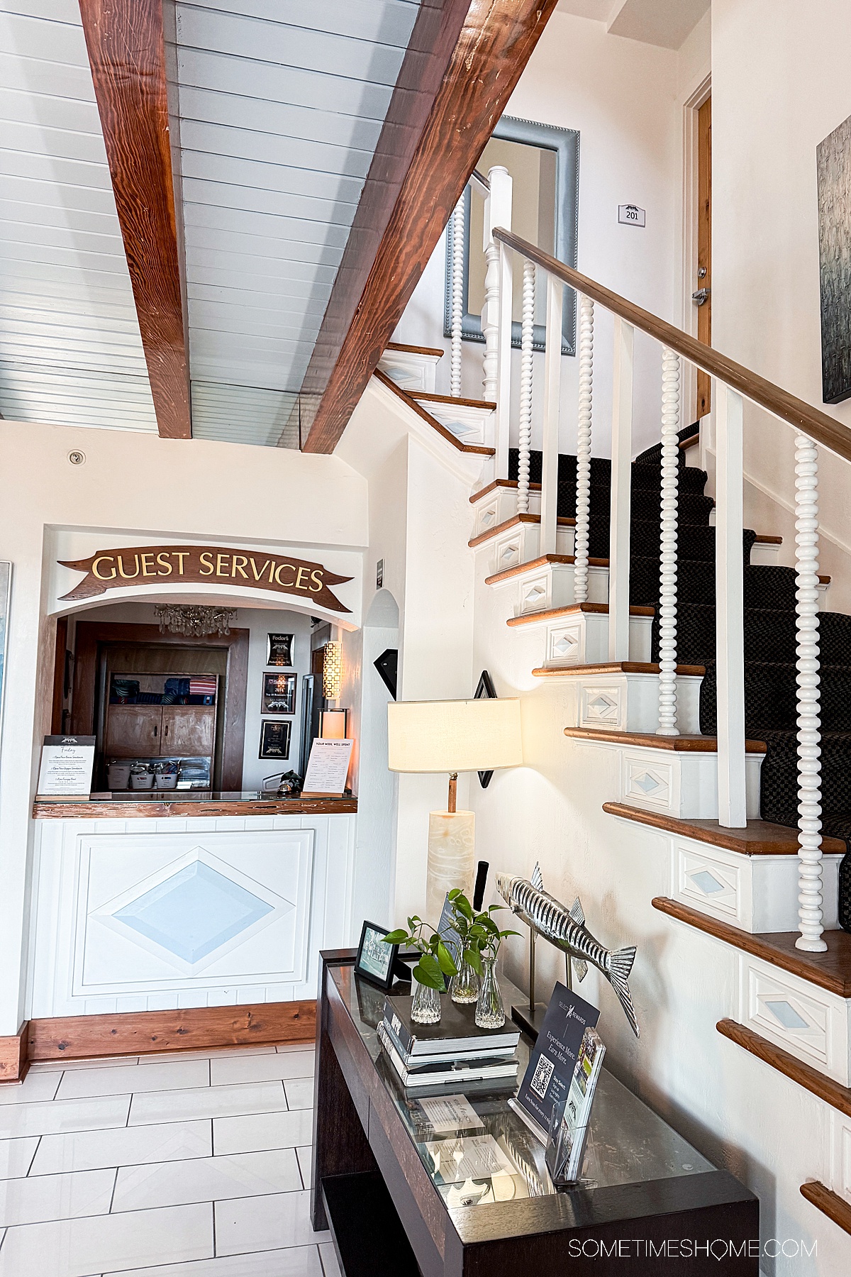Staircase with the "guest services" desk area at a boutique hotel.